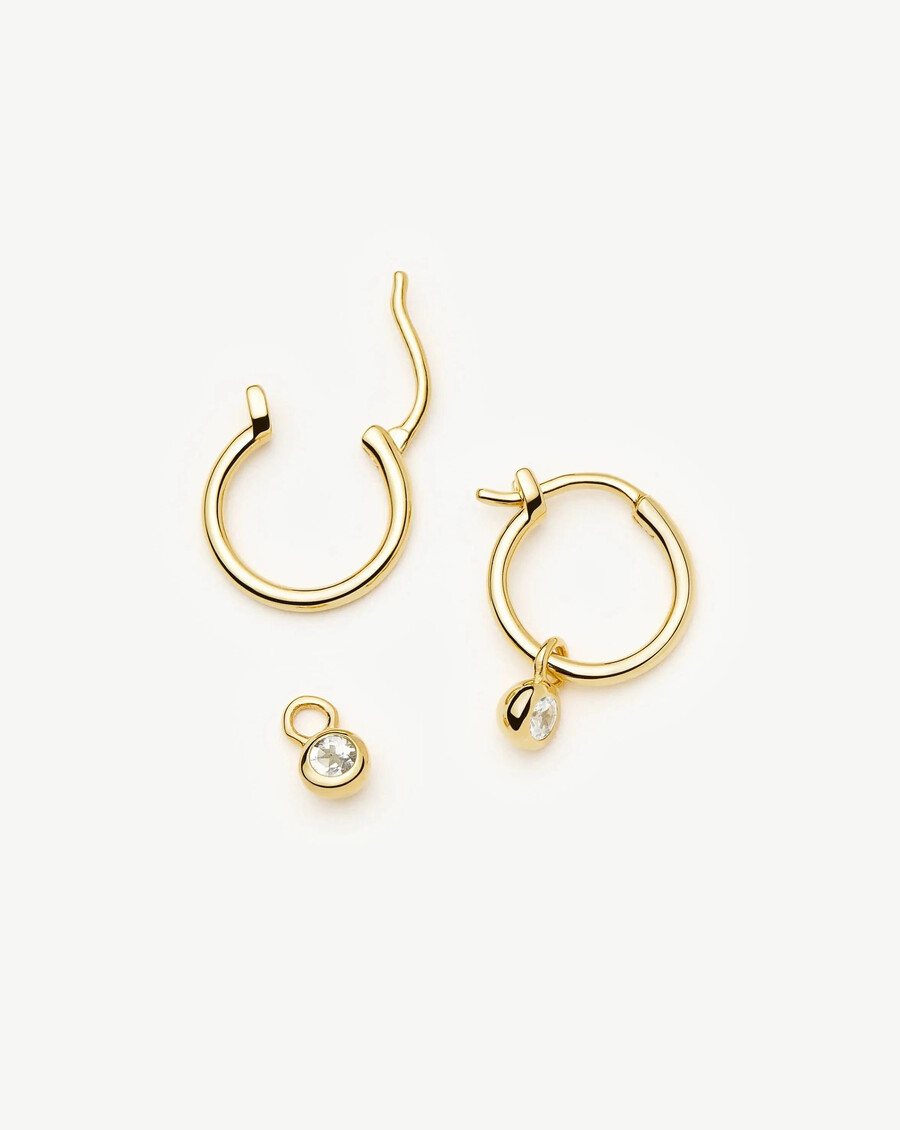 mini aretes de aro dorados con dije de piedra natal de abril - cristal