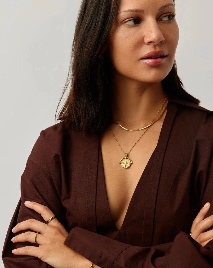 conjunto de collar dorado con arco romano y serpiente de lucy williams